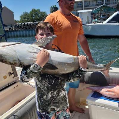 a man holding a fish on a boat