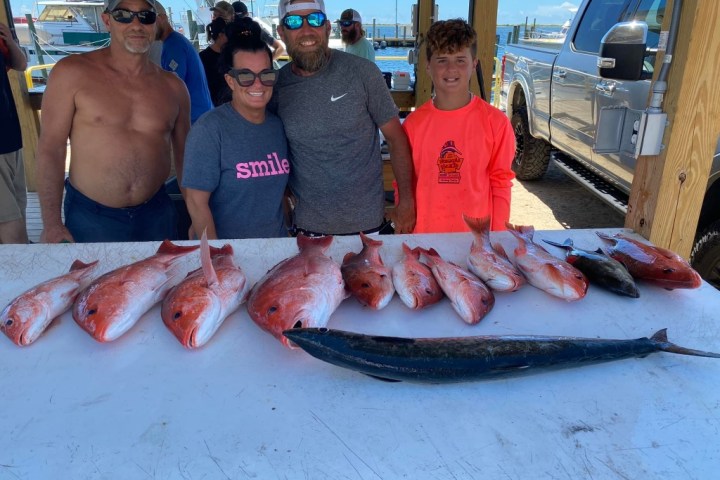 a group of people standing in front of a fish