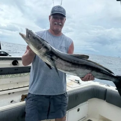 a man holding a fish on a boat