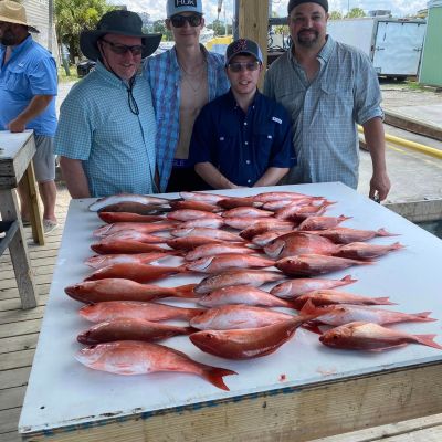 a group of people standing on top of a cutting board with a cake